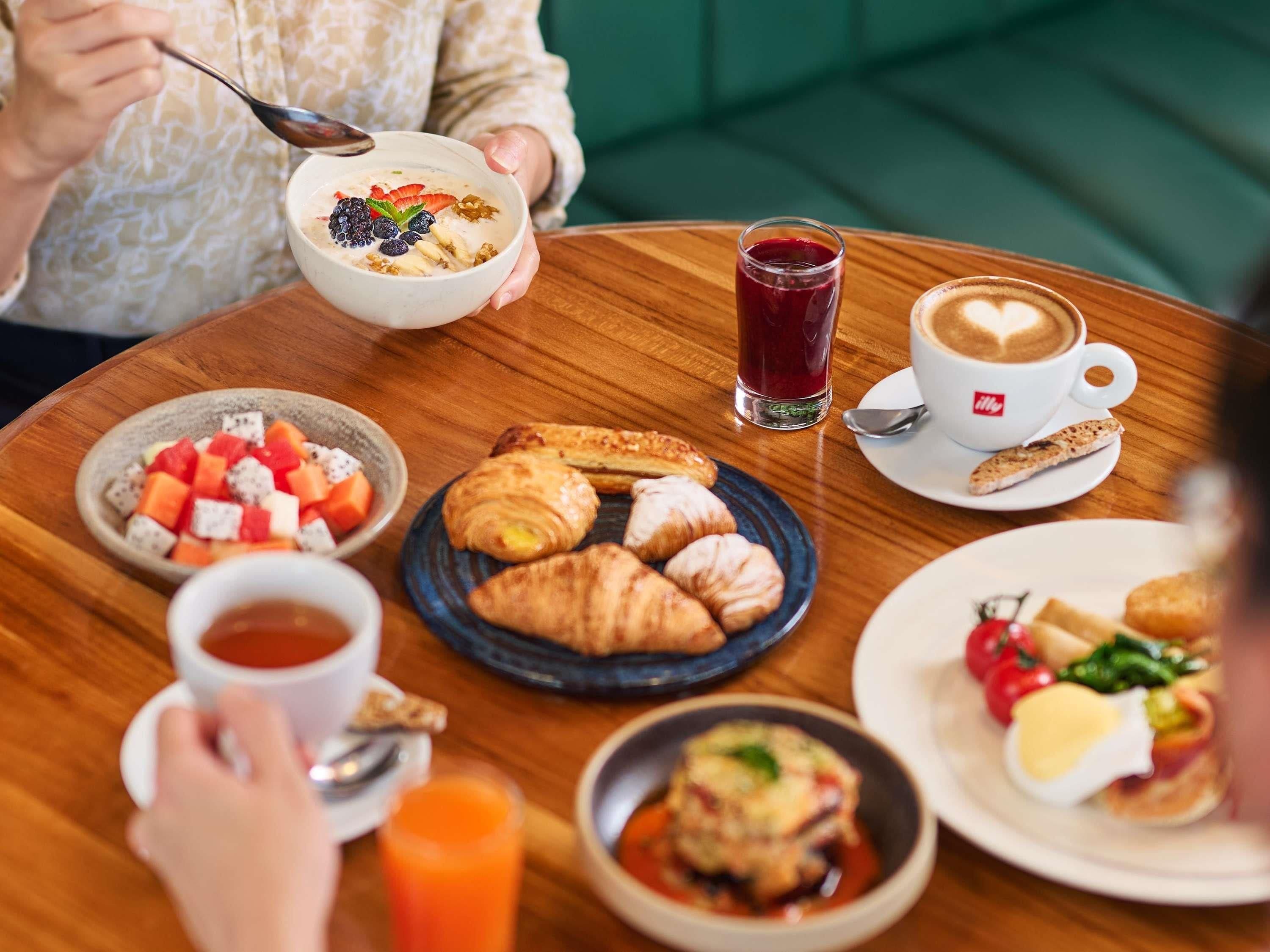 Una mesa de madera con diferentes alimentos y bebidas para el desayuno.