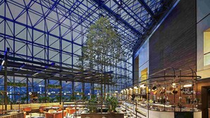 Een ruime, overdekte ruimte met een hoge plafond, een centrale bedieningspost en zitgedeeltes.