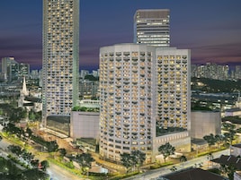 A high-rise building with multiple floors, surrounded by other tall buildings and a cityscape in the background.
