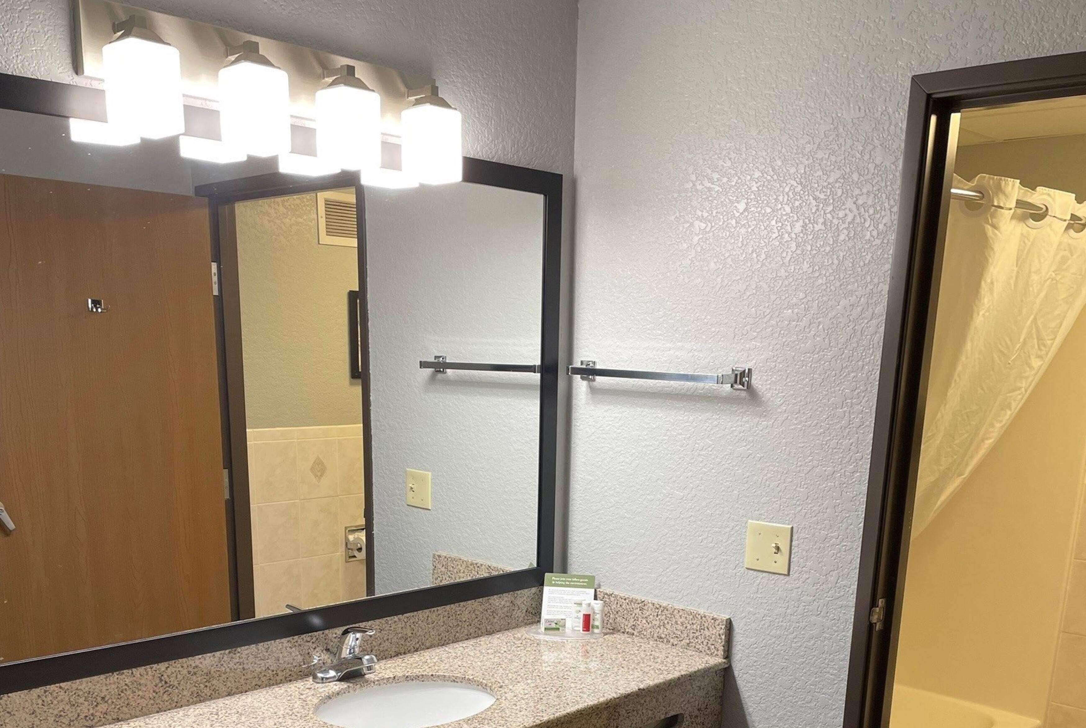 Une salle de bain équipée d’un lavabo, d’un miroir et d’un porte-serviettes.