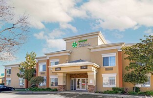 A Stay America hotel with a lobby entrance, numbered 330, and a parking lot in front.