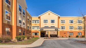 A multi-story hotel with a central lobby, multiple windows, and a clear sky. - Extended Stay America Suites Providence Warwick (Warwick)