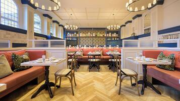 Un restaurant avec des banquettes, des tables et un coin bar.