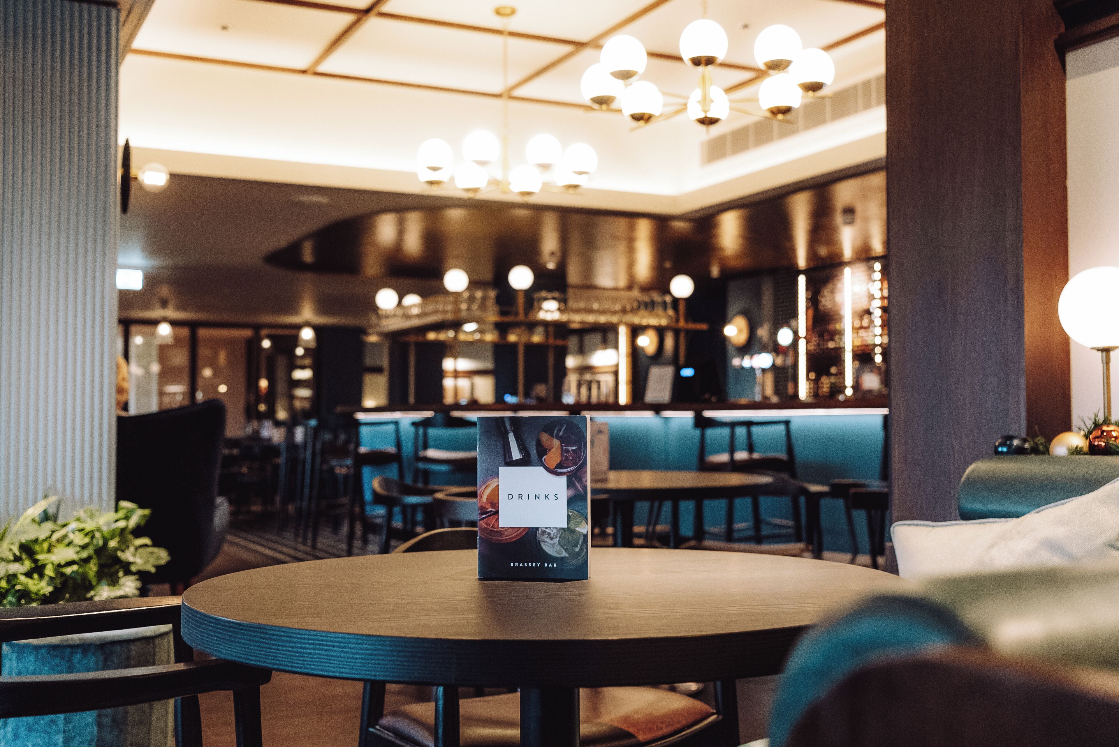 A bar area with a menu stand displaying 'Drinks' and 'Brasserie Bar'.