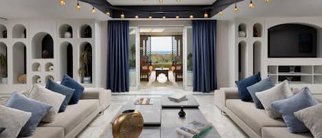 A modern living room with a sofa, coffee table, and a view to the outside.
