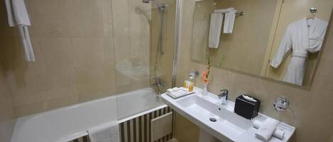 A modern bathroom with a bathtub, a sink, a mirror, and a shower.