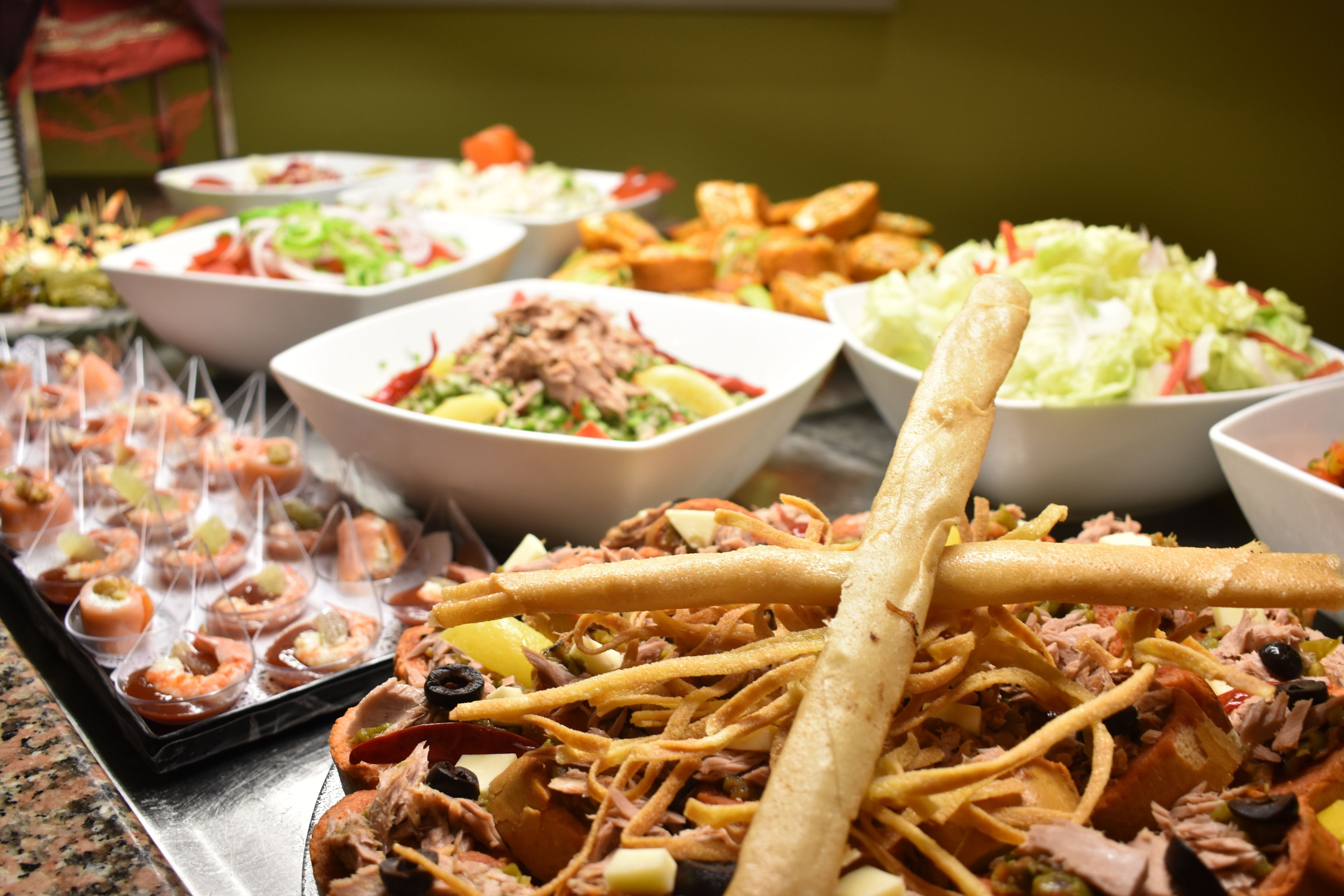 Un buffet con diversi piatti, tra cui tacos, insalate e antipasti.