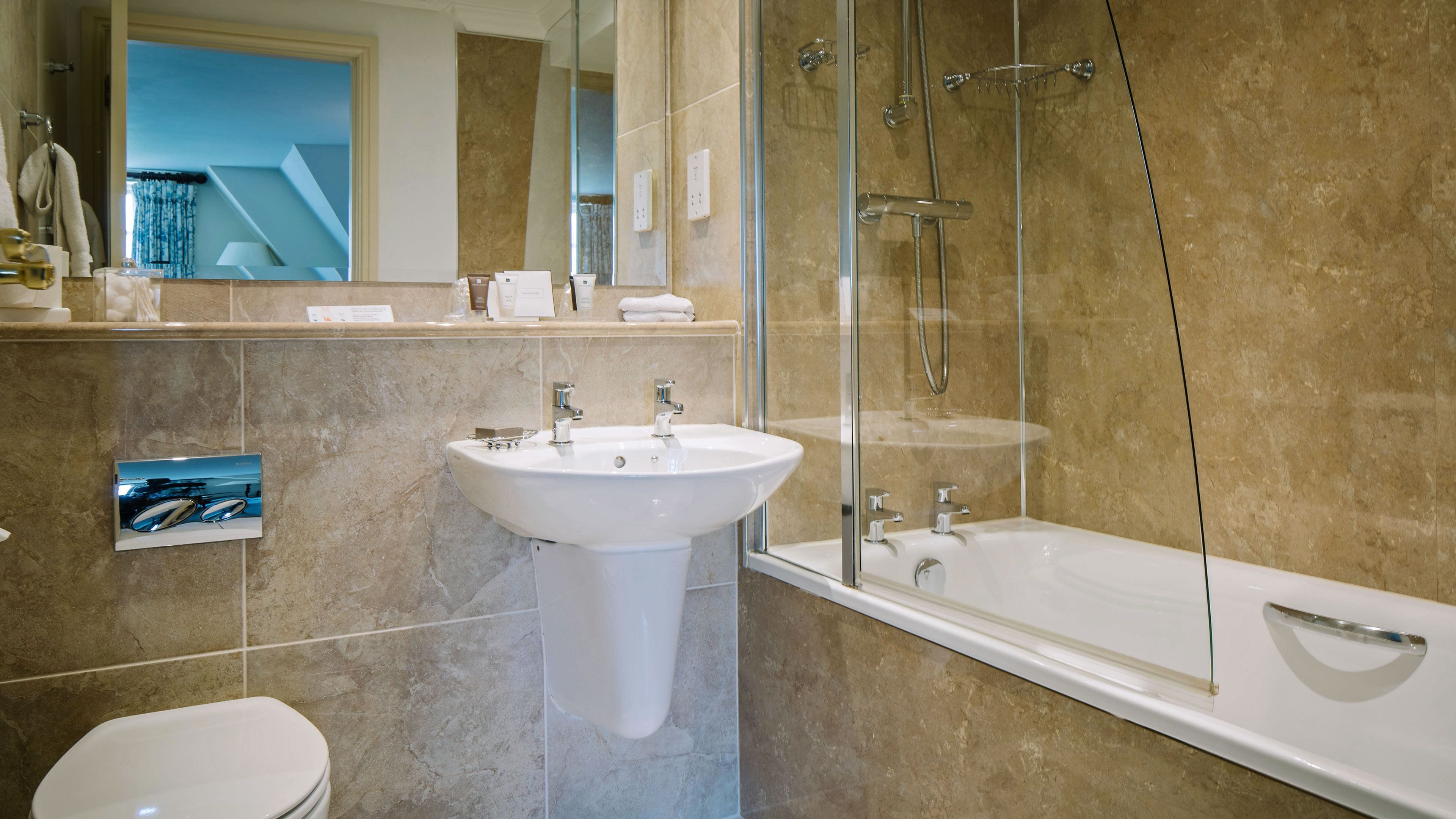 A modern bathroom with a large bathtub, a sink, and a toilet.