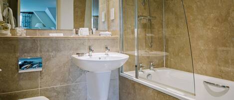 A modern bathroom with a large bathtub, a sink, and a toilet.