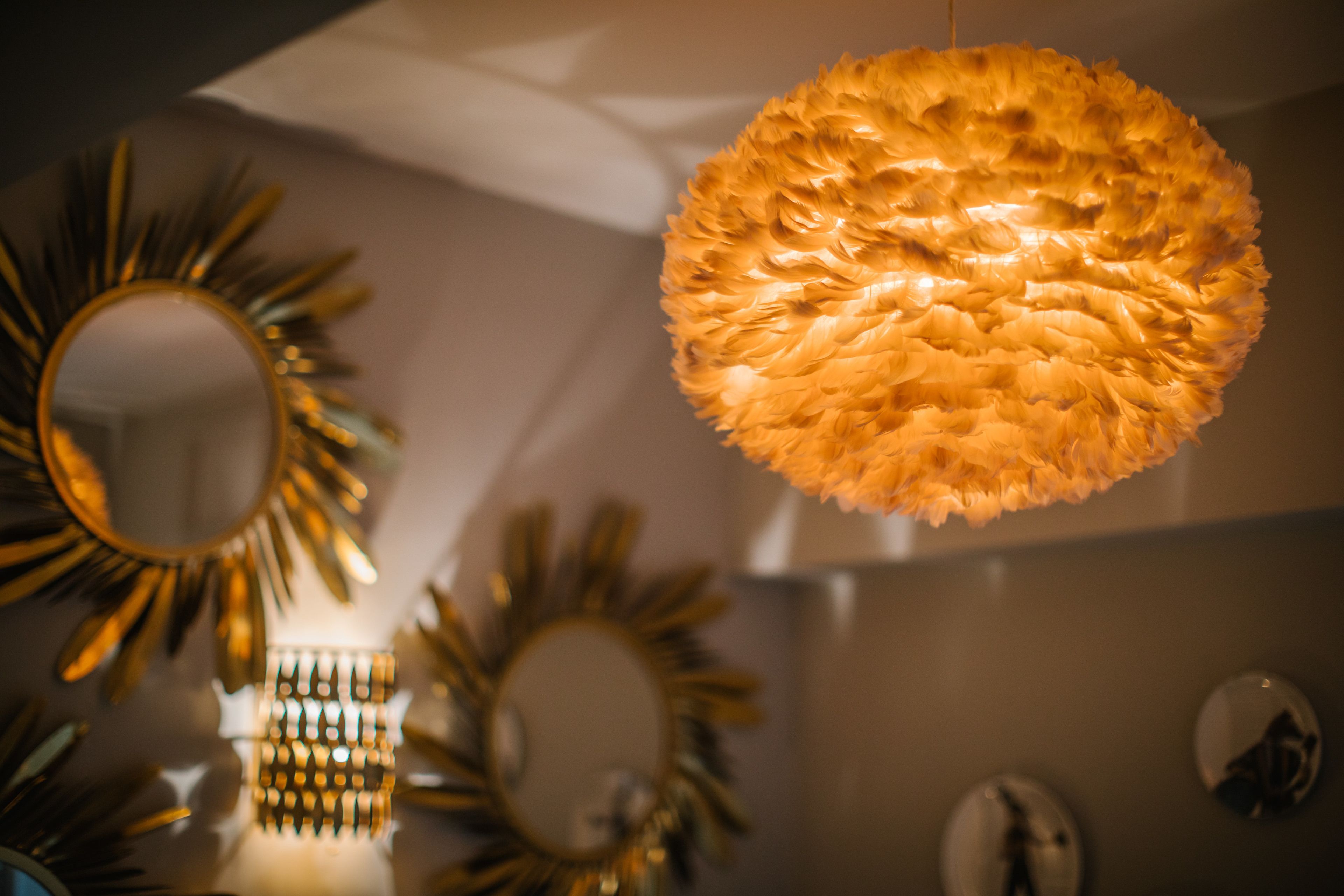 A room with a decorative ceiling light fixture and multiple wall-mounted mirrors.