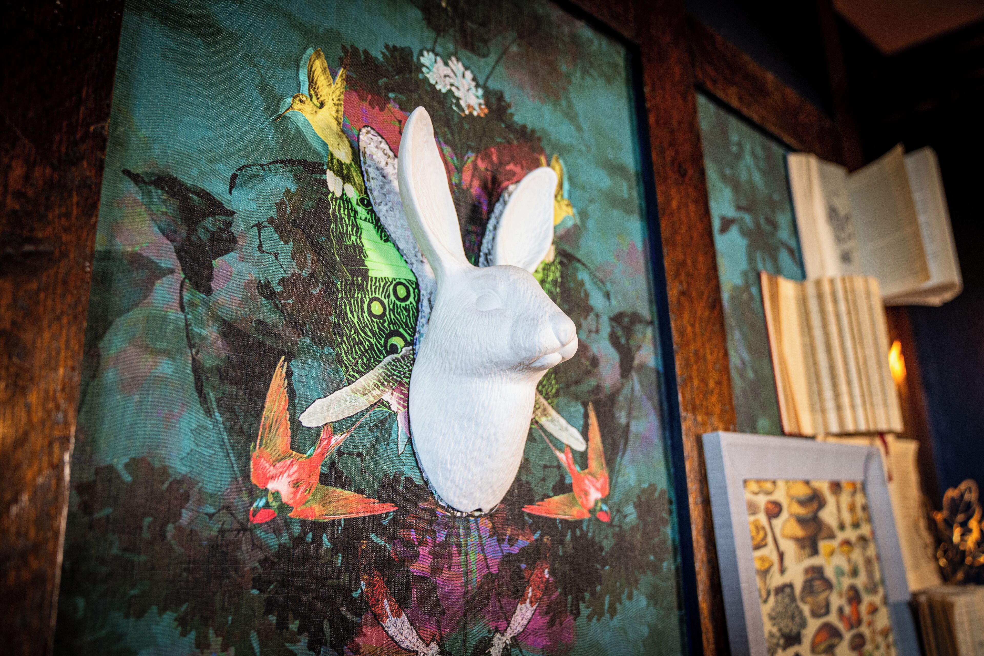 A framed artwork with a white rabbit head and colorful abstract patterns.