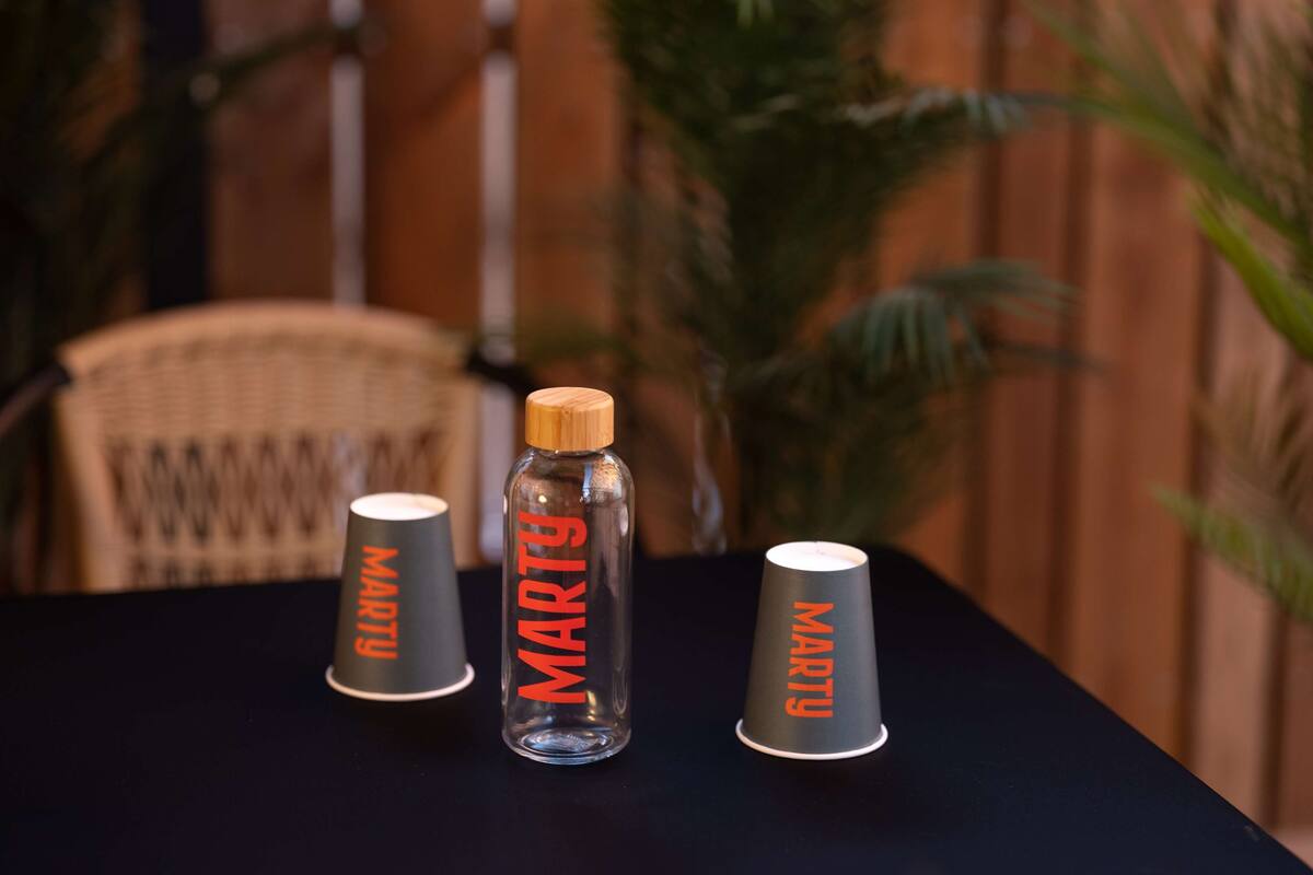 A table with three cups and a bottle, each labeled "MARTY".
