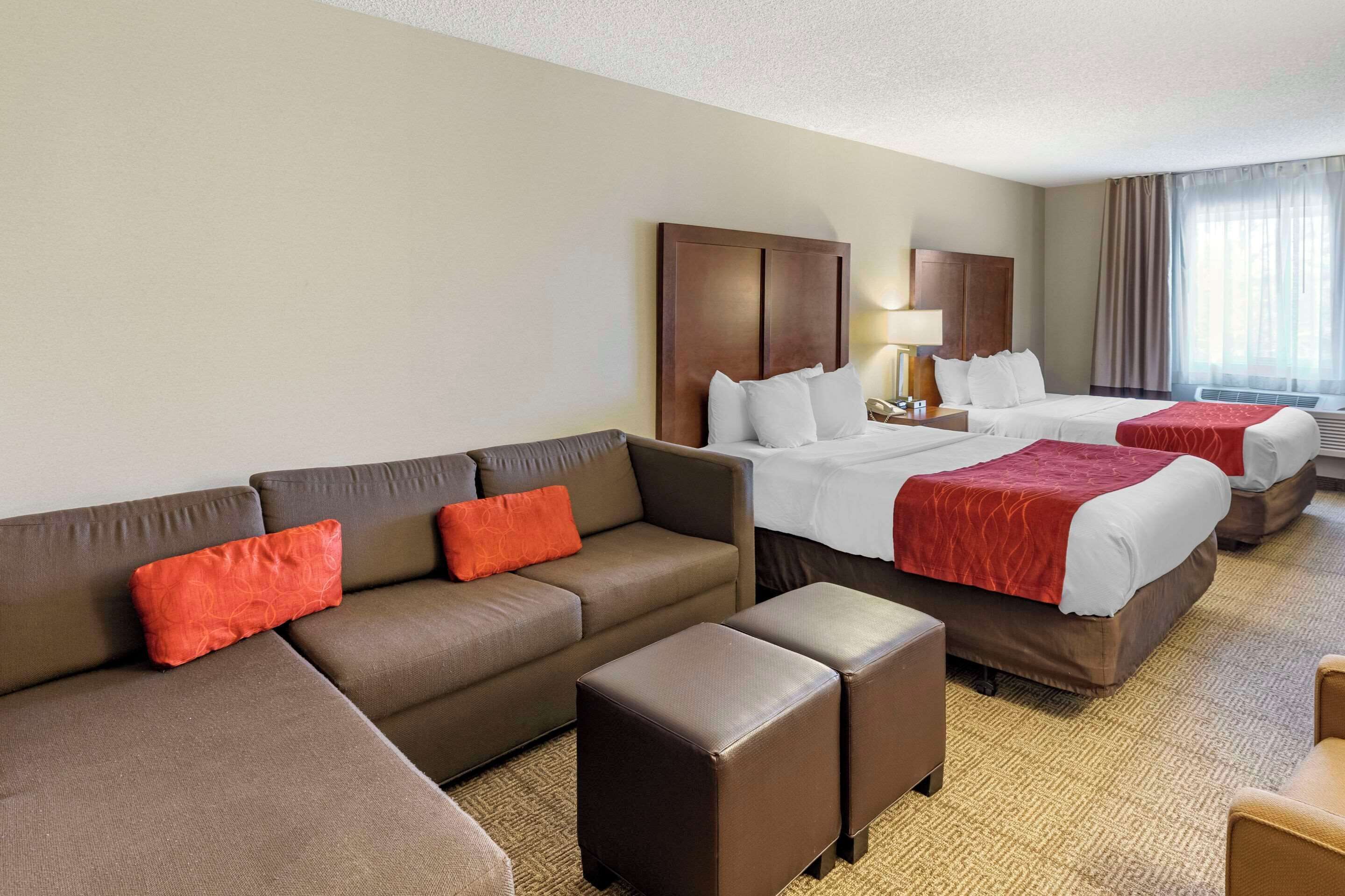 Una habitación de hotel con una cama grande, un sofá y una mesita.