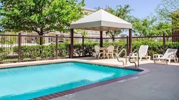 Alberca al aire libre y camastros