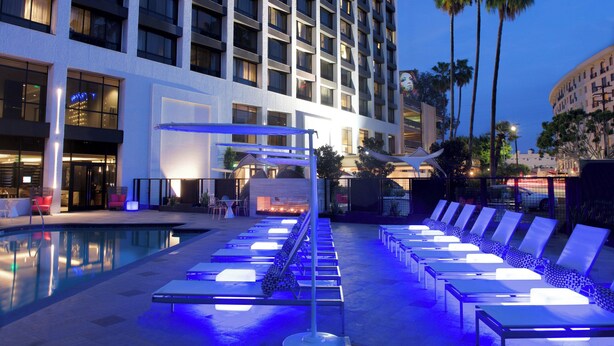 Uma área de piscina de hotel com espreguiçadeiras e piscina.
