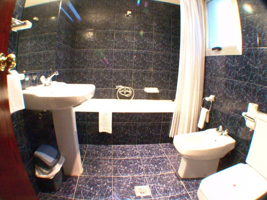 Une salle de bain équipée d’un lavabo, d’une baignoire, de toilettes et d’une douche.