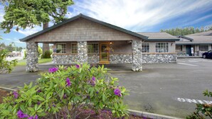 A building with a stone facade, a wooden entrance, and a parking lot.