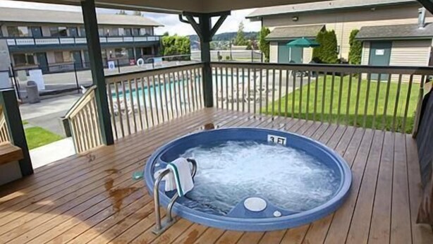 A hot tub on a wooden deck with a view of a residential area.