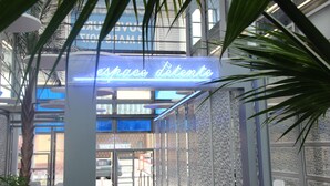 A modern interior with a neon sign reading "espacio detente" and a glass door entrance.