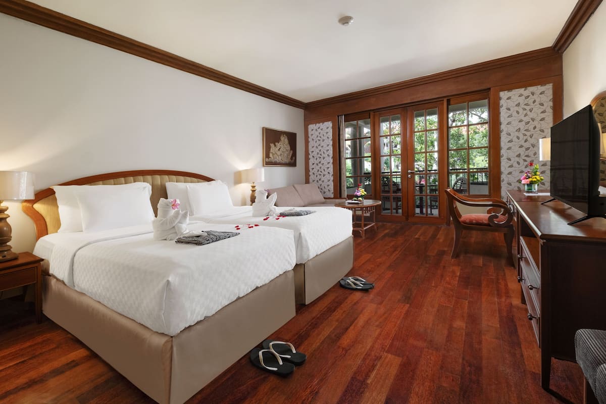 Une chambre d’hôtel avec un grand lit, un bureau, une chaise et un téléviseur.