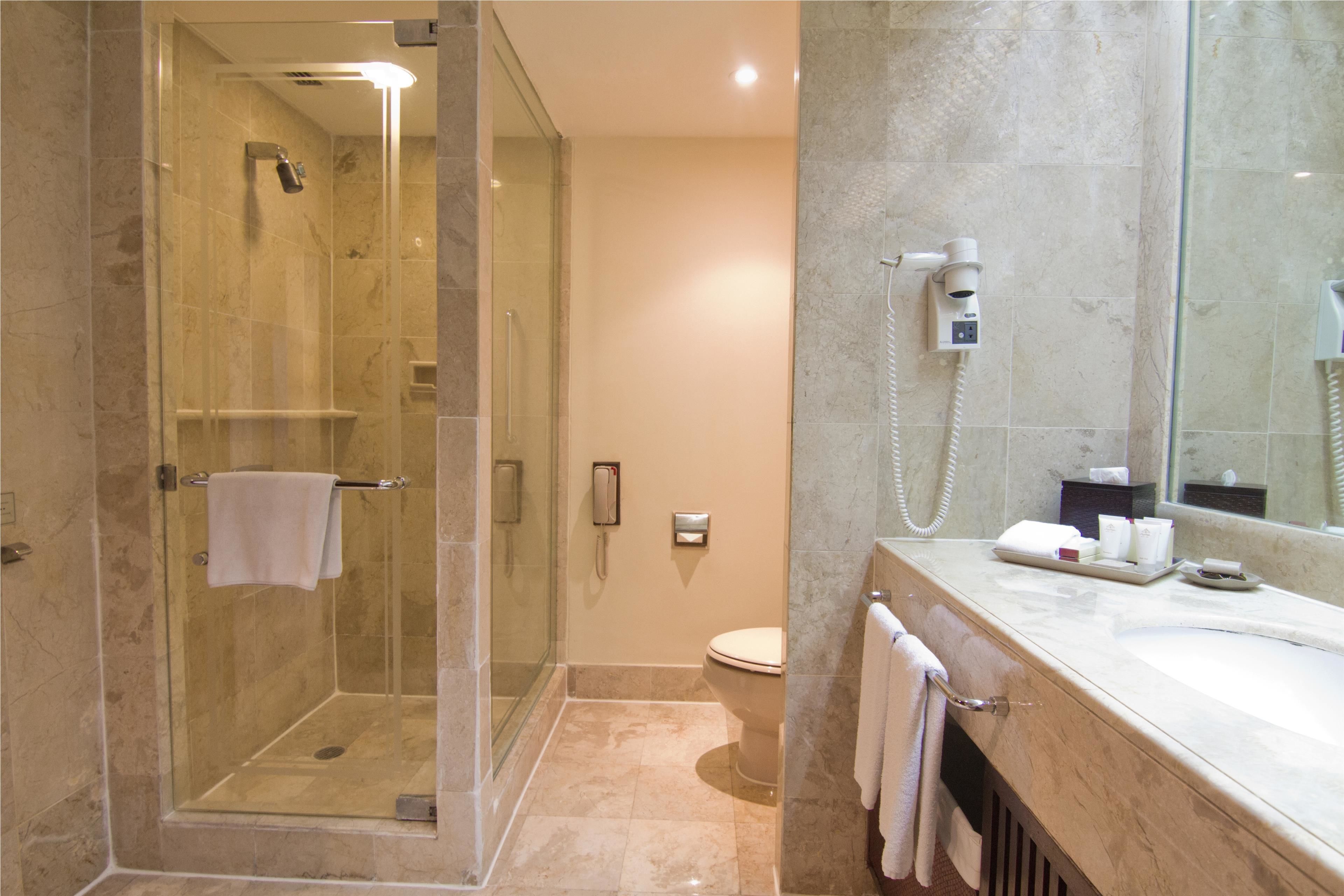 A modern bathroom with a glass-enclosed shower, a toilet, and a vanity with a mirror.