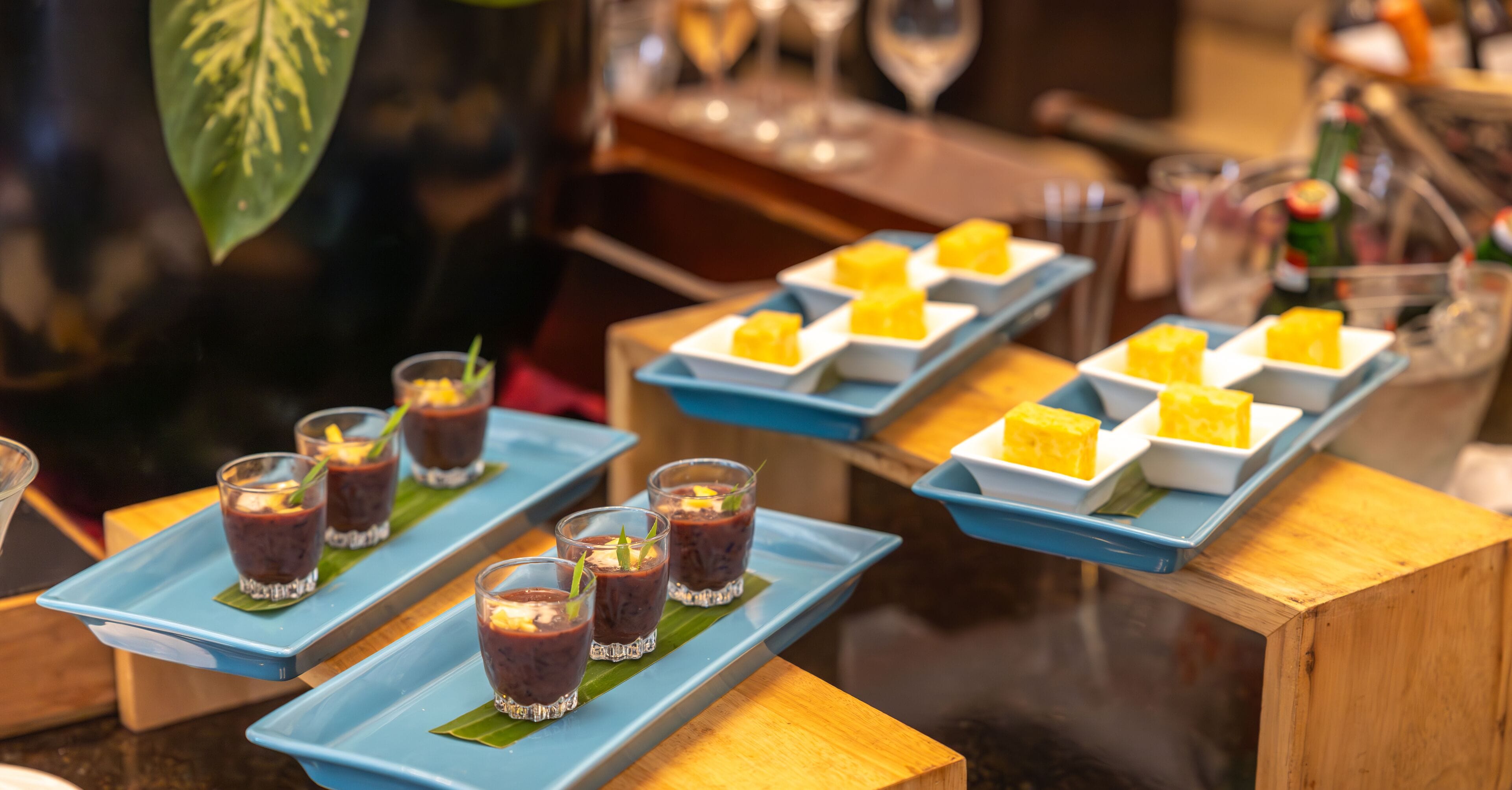 Una exhibición de postres con diversas delicias a base de frutas sobre bandejas azules.