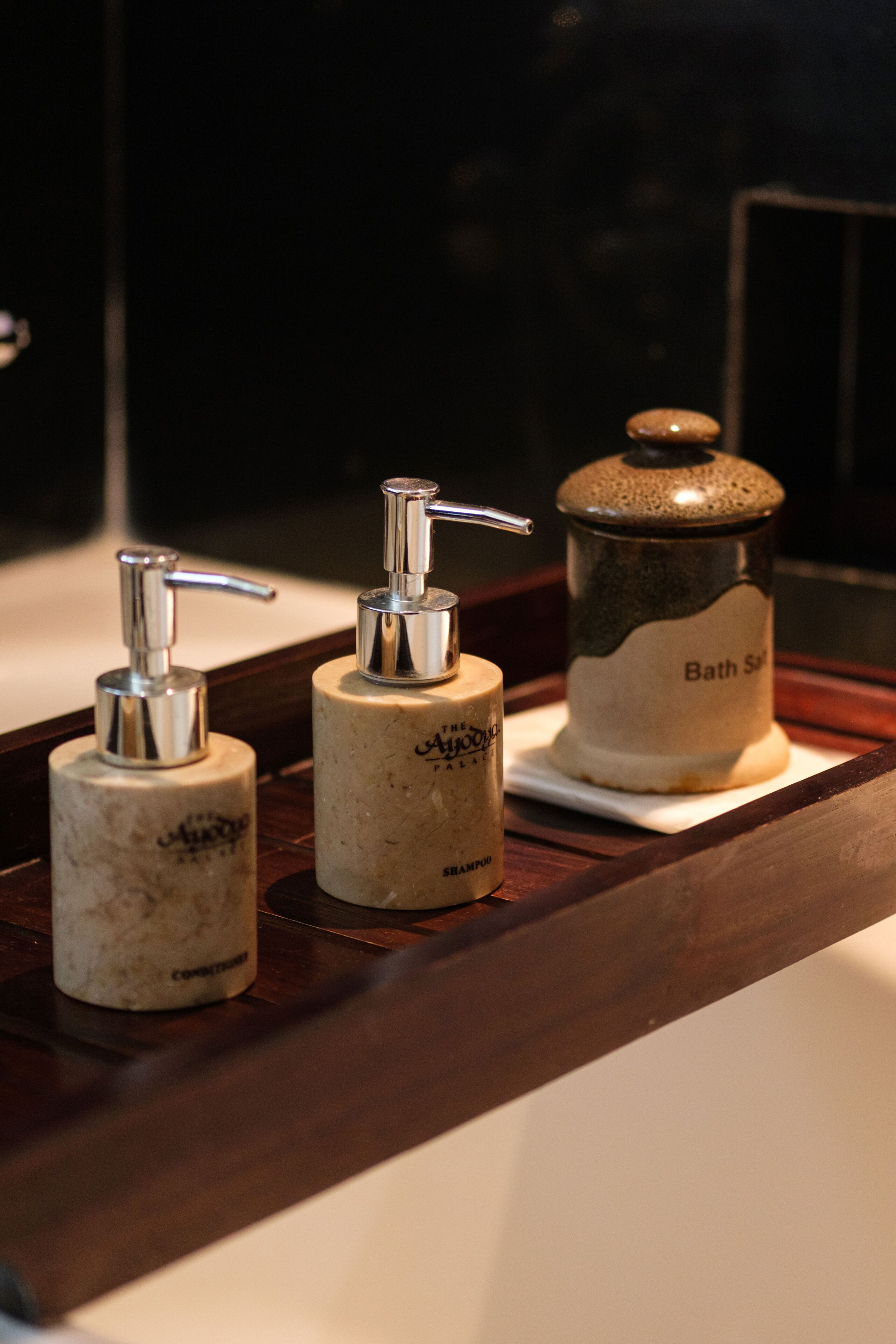 A bathroom vanity with a soap dispenser and a bath salts container.
