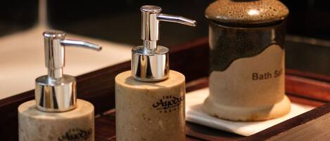 A bathroom vanity with a soap dispenser and a bath salts container.