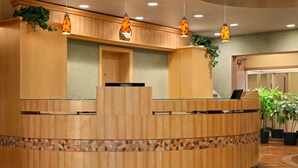 Una recepción con detalles de madera, un borde de mosaicos y lámparas colgantes.