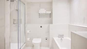 Un baño moderno con ducha envuelta en vidrio, inodoro y bañera.