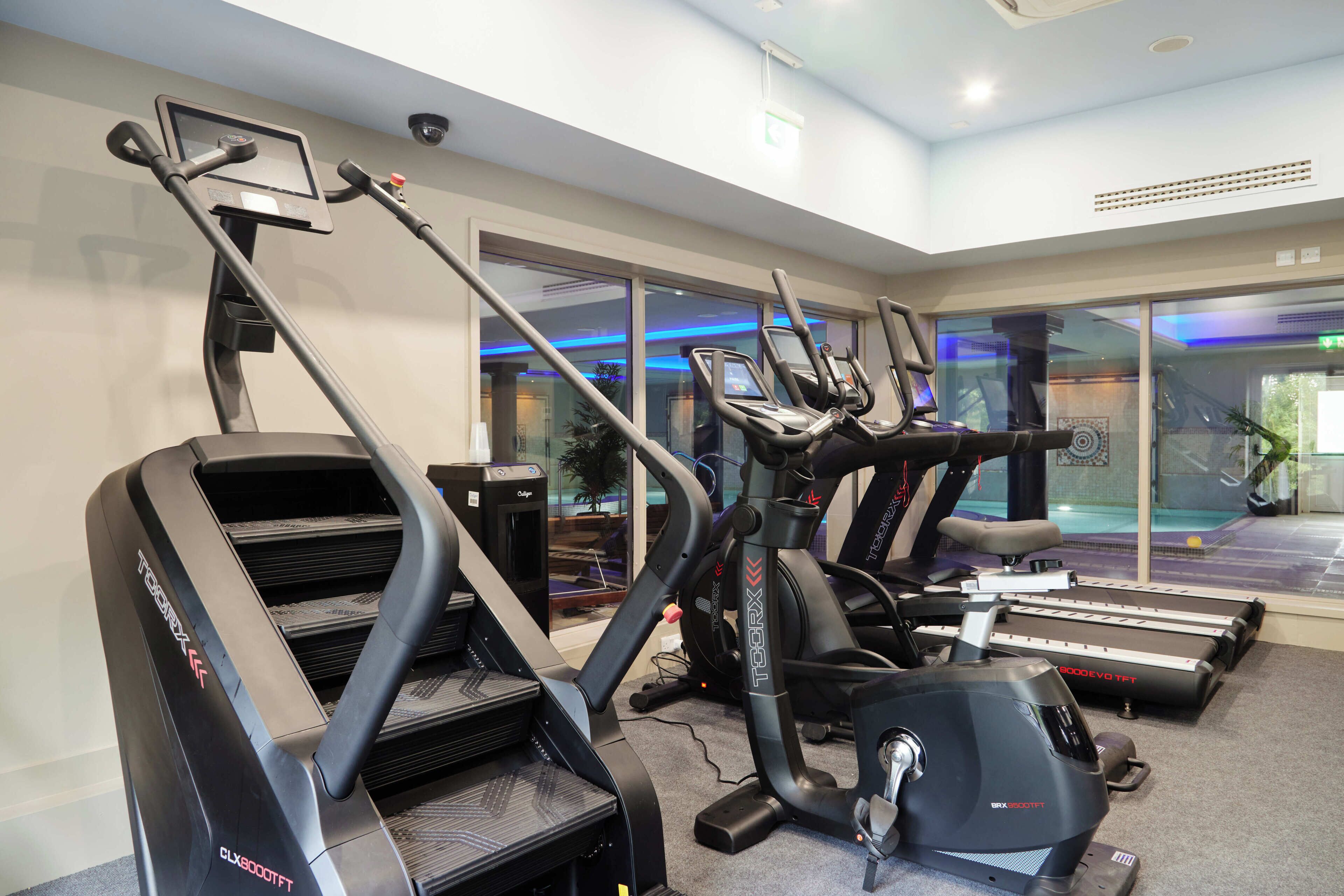 A gym with treadmills, ellipticals, and a stationary bike.