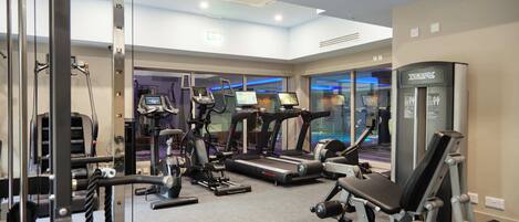 A gym with treadmills, elliptical machines, and weightlifting equipment.