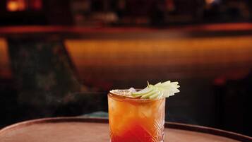 A cocktail on a tray with a blurred bar in the background.