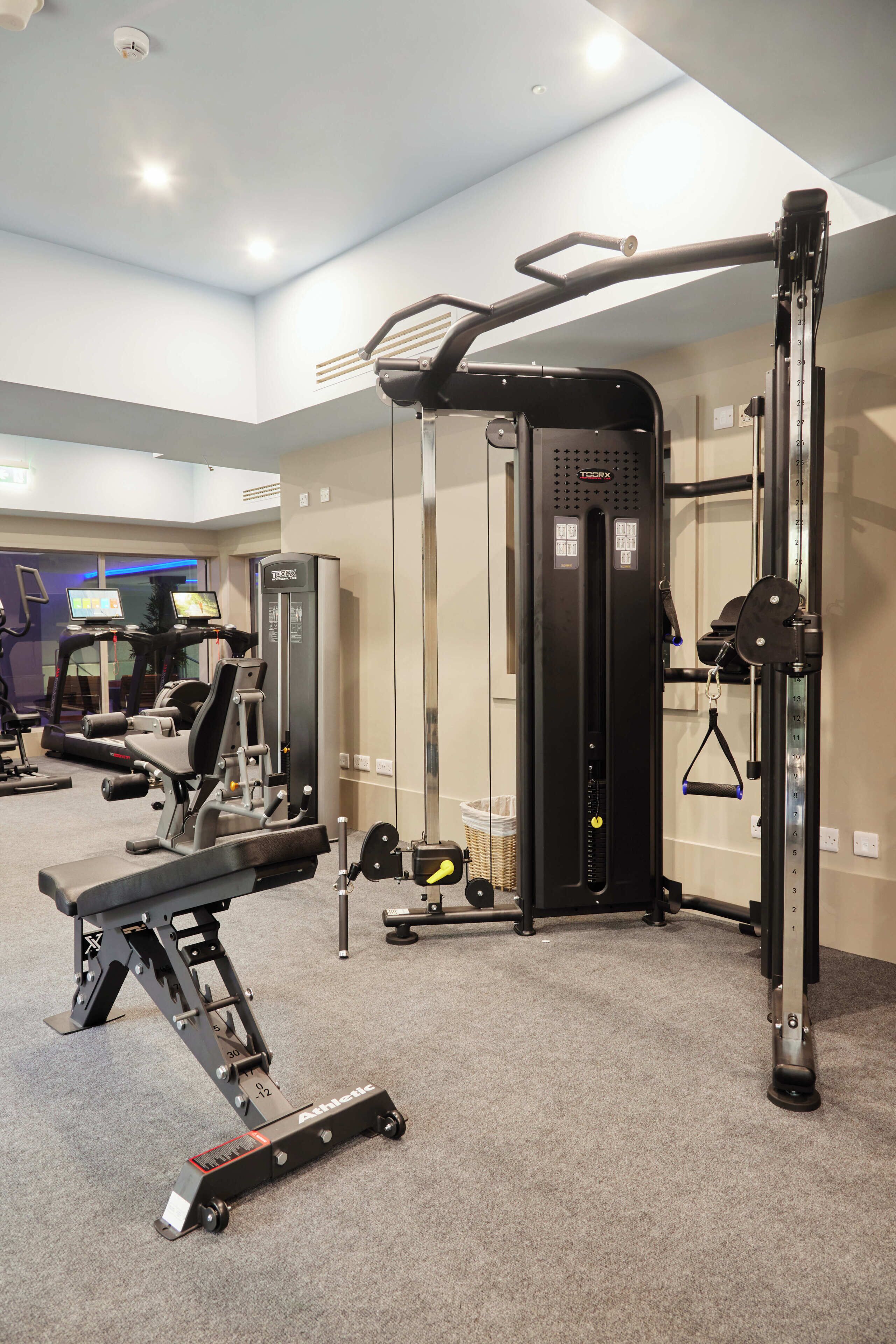 A gym with exercise equipment, a treadmill, and a weight bench.
