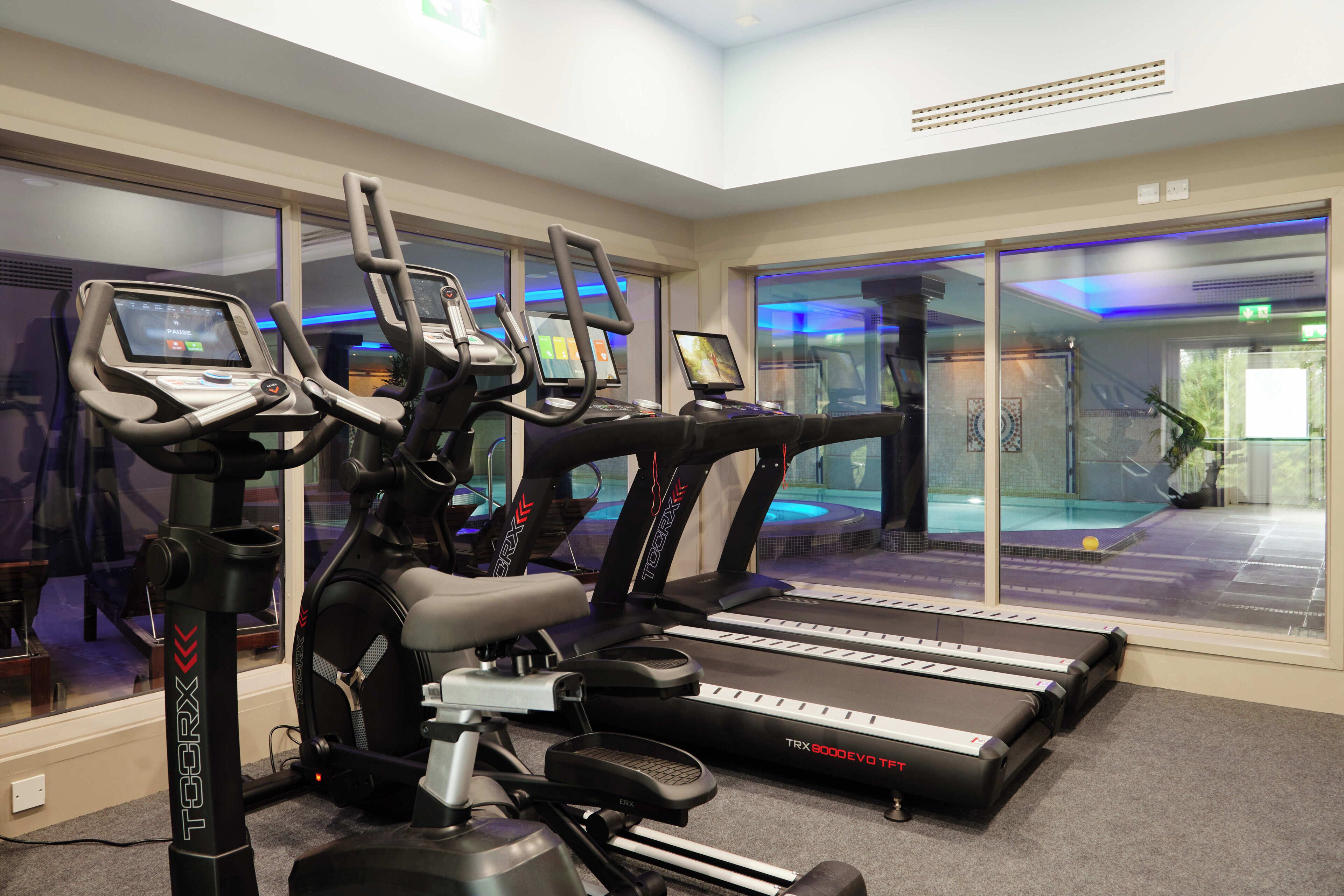 A gym with treadmills, stationary bikes, and an elliptical machine.