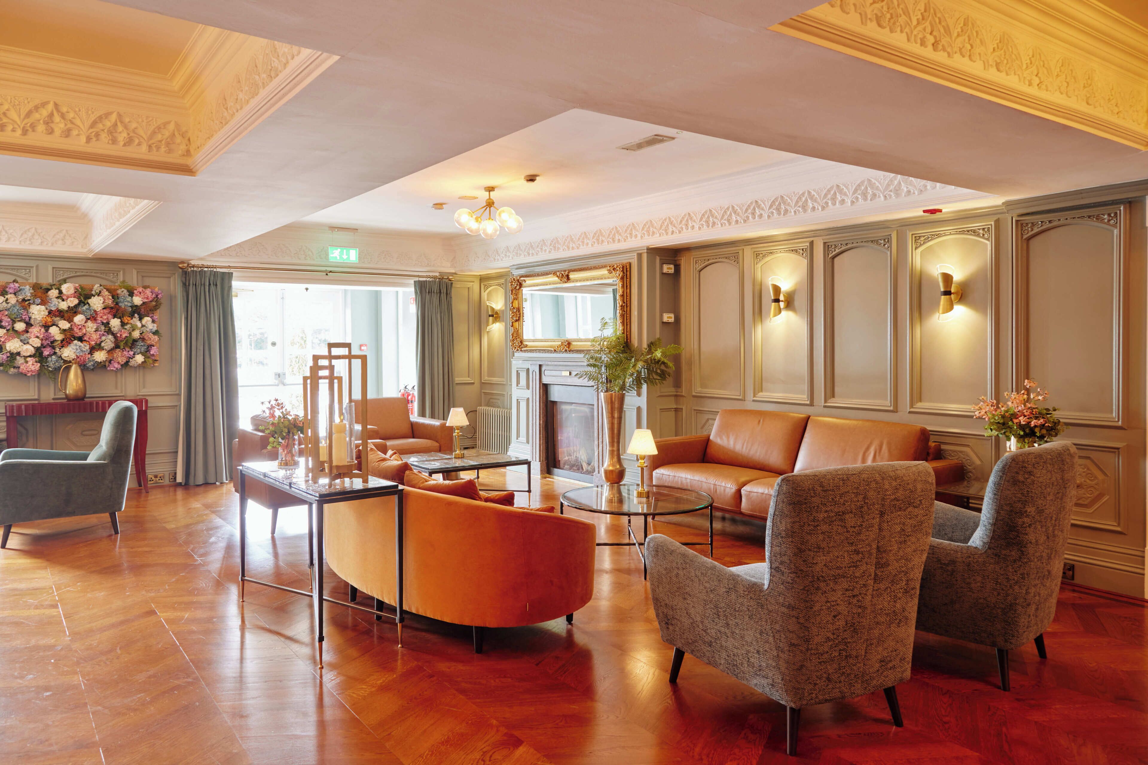 A spacious lobby with a fireplace, seating area, and decorative wall sconces.