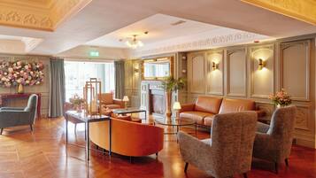 A spacious lobby with a fireplace, seating area, and decorative wall sconces.