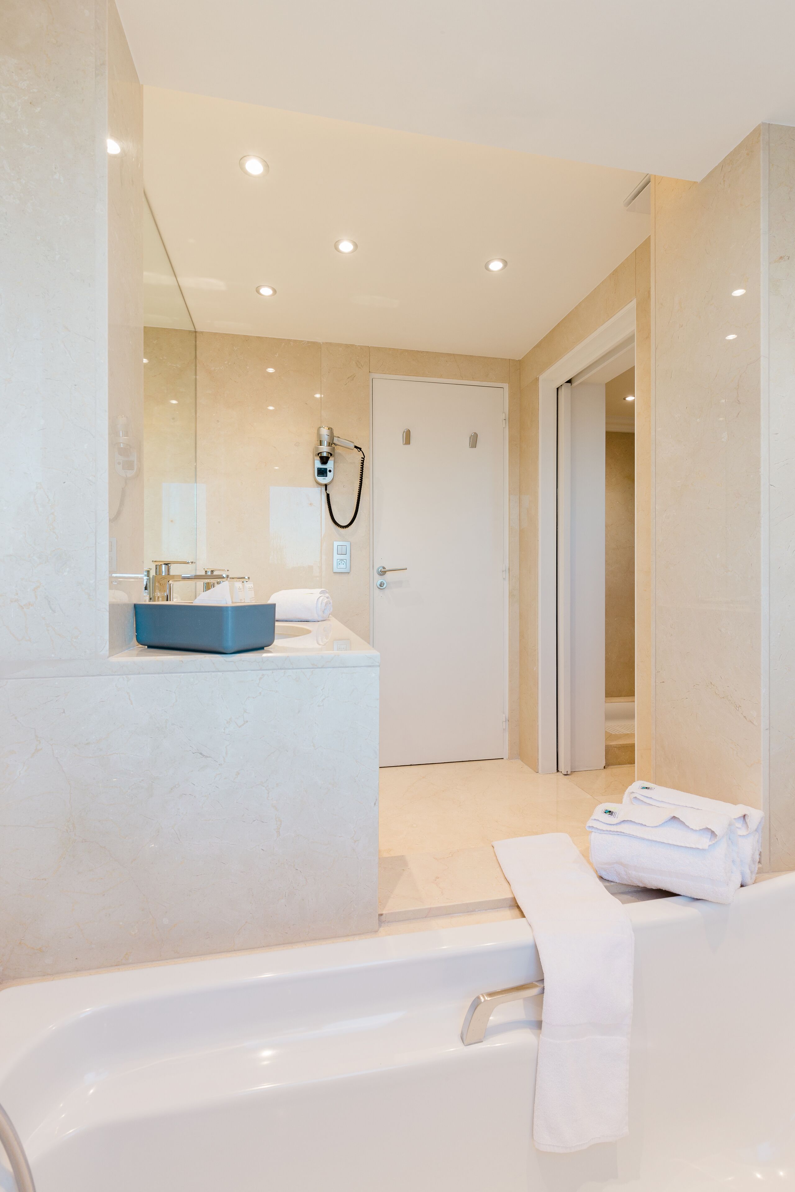A modern bathroom with a bathtub, a sink, and a mirror.