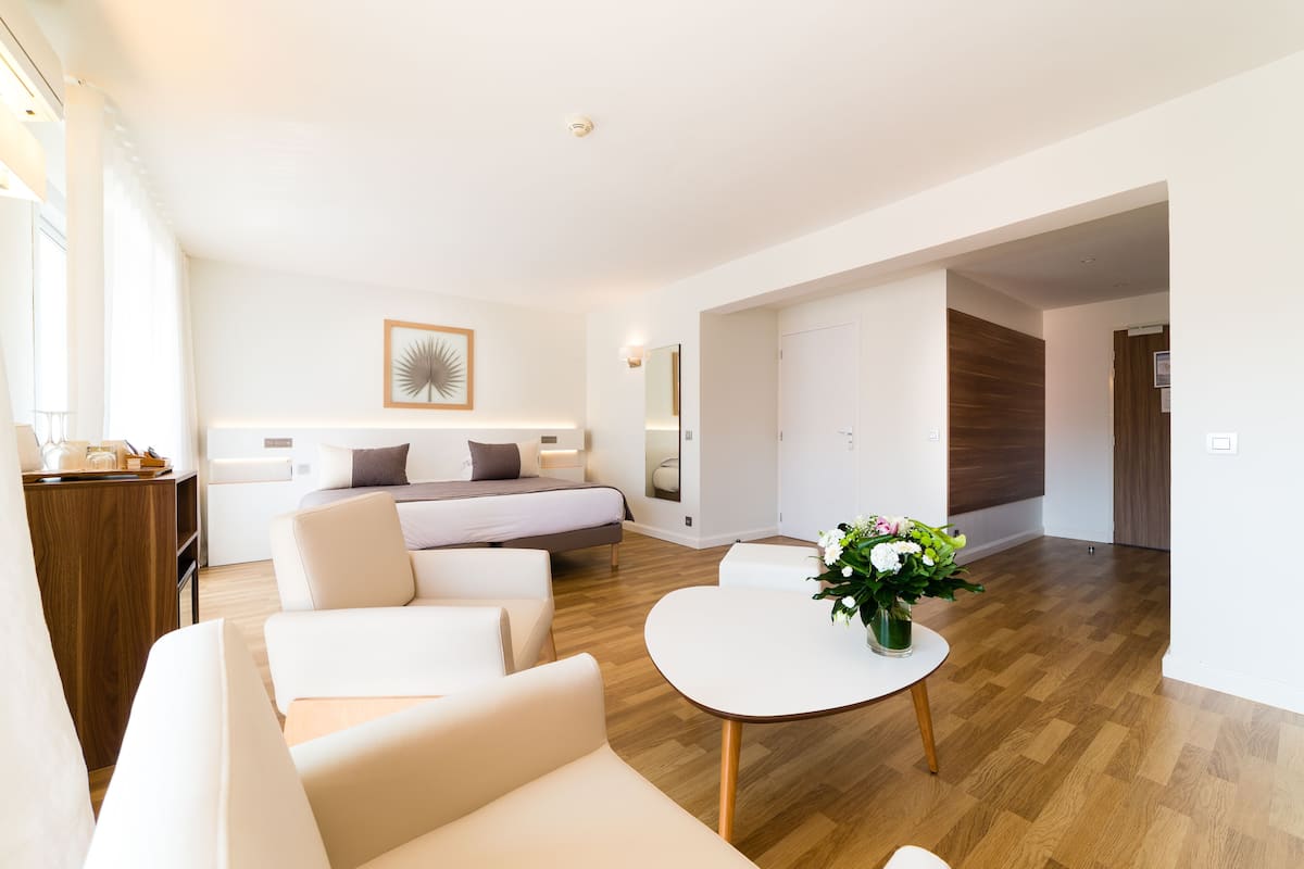 A modern, well-lit living room with a sofa, a coffee table, and a bed.