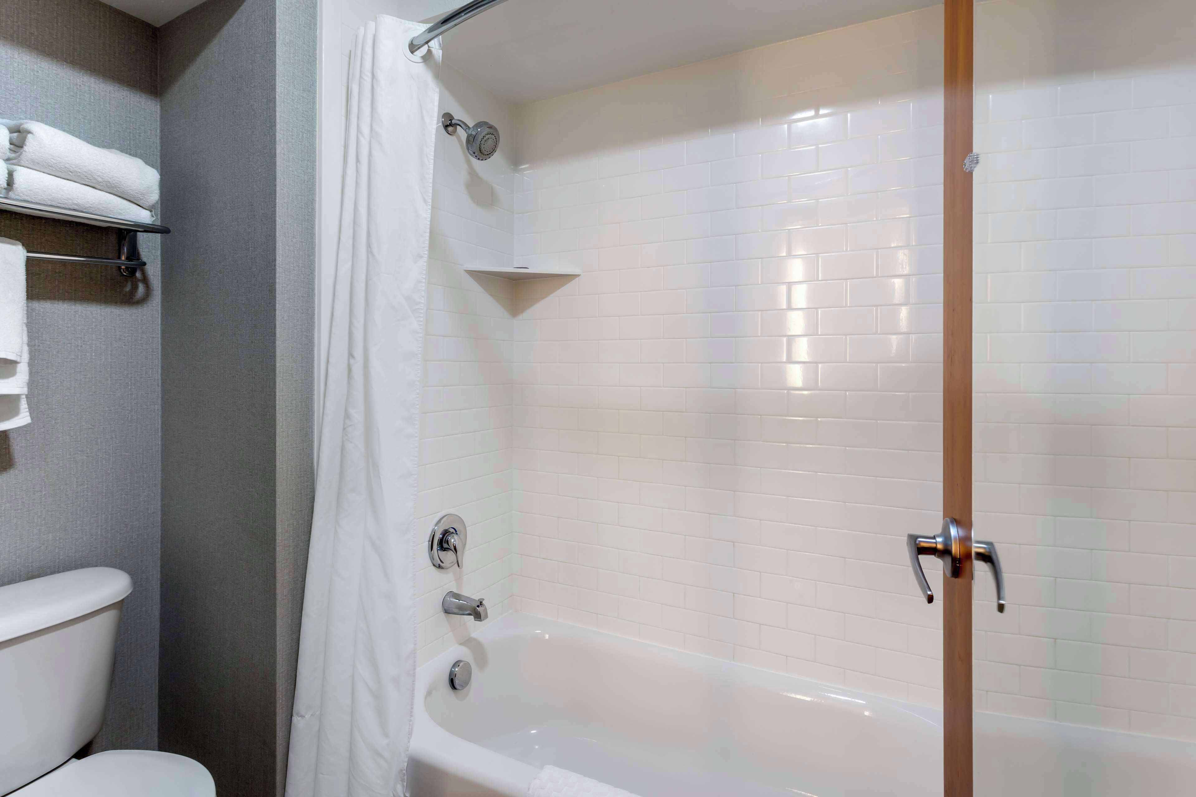 Une salle de bain avec une baignoire blanche, des toilettes et un porte-serviettes.