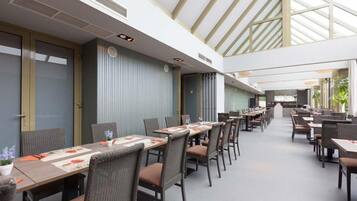 A spacious indoor dining area with high ceilings and natural light from skylights.