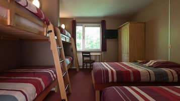 A dormitory room with bunk beds, a desk, a chair, a television, and a wardrobe.