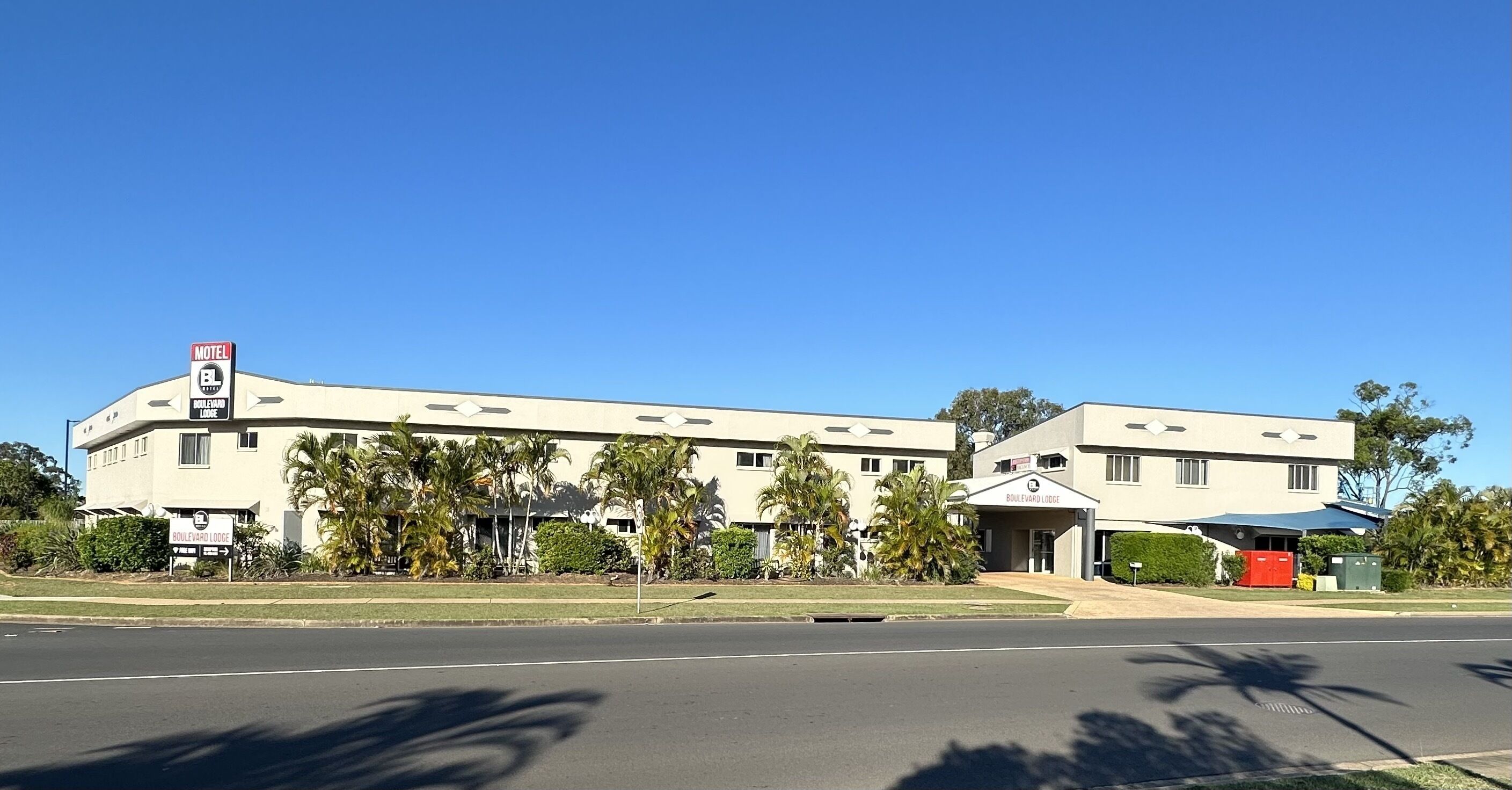 A motel with a sign indicating 'Boulevard Lodge' and 'Motel BL'.