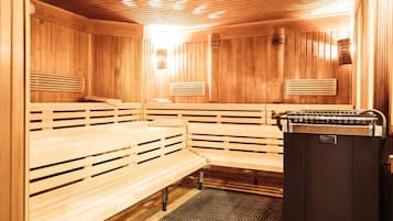 A sauna with wooden benches and a steam generator.