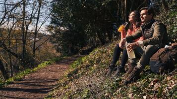 Un couple est assis sur un chemin de terre, entouré d’arbres.