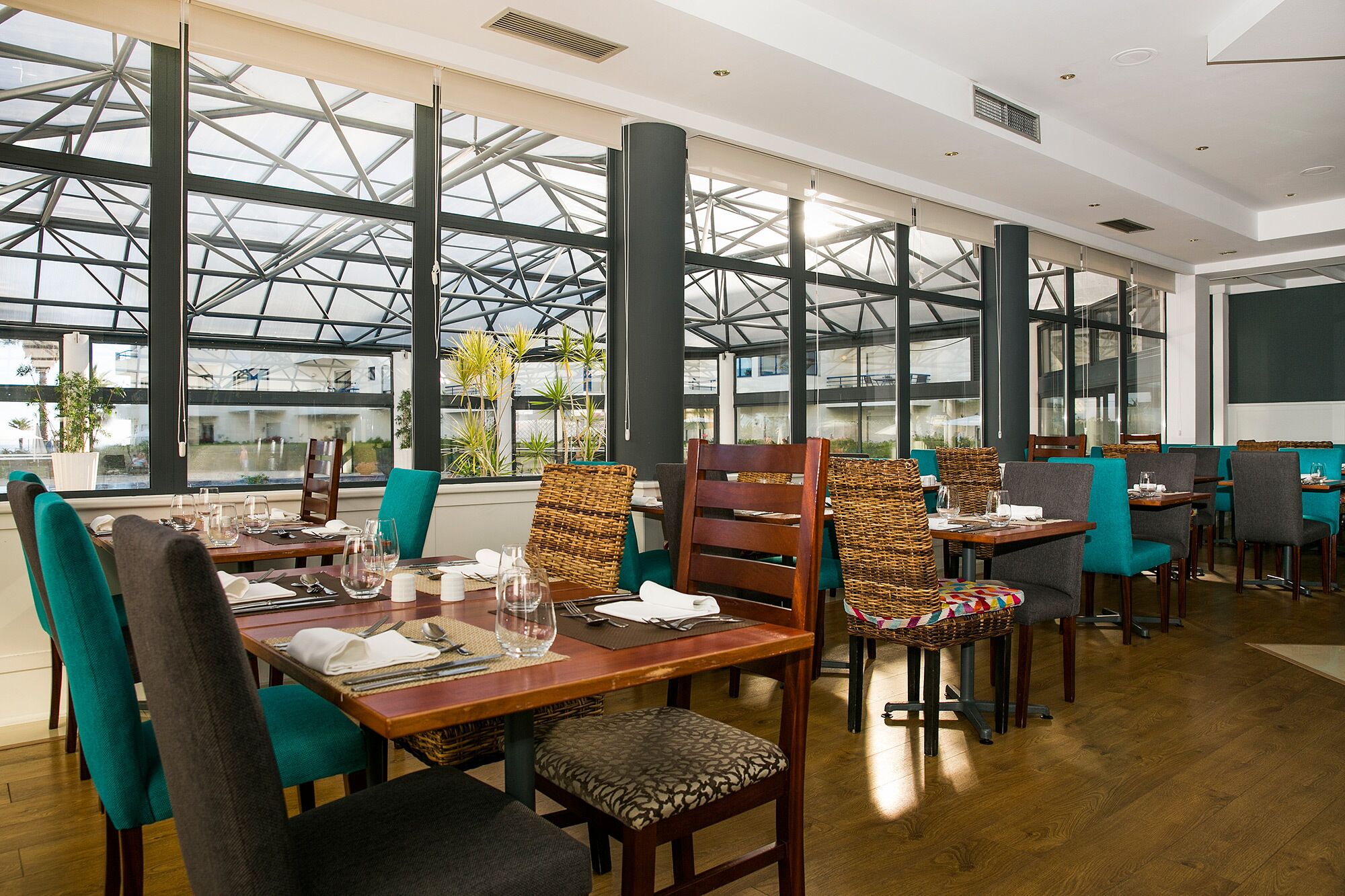 A restaurant with high ceilings, large windows, and modern furniture.
