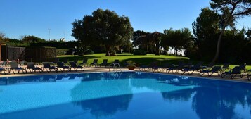 Una piscina cubierta, una piscina al aire libre, tumbonas