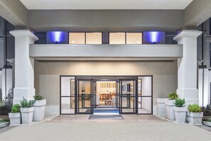 A hotel entrance with a double door, a reception desk, and a seating area visible through the glass doors. - Holiday Inn Express & Suites Greenville-Spartanburg (Duncan) by IHG (Duncan)