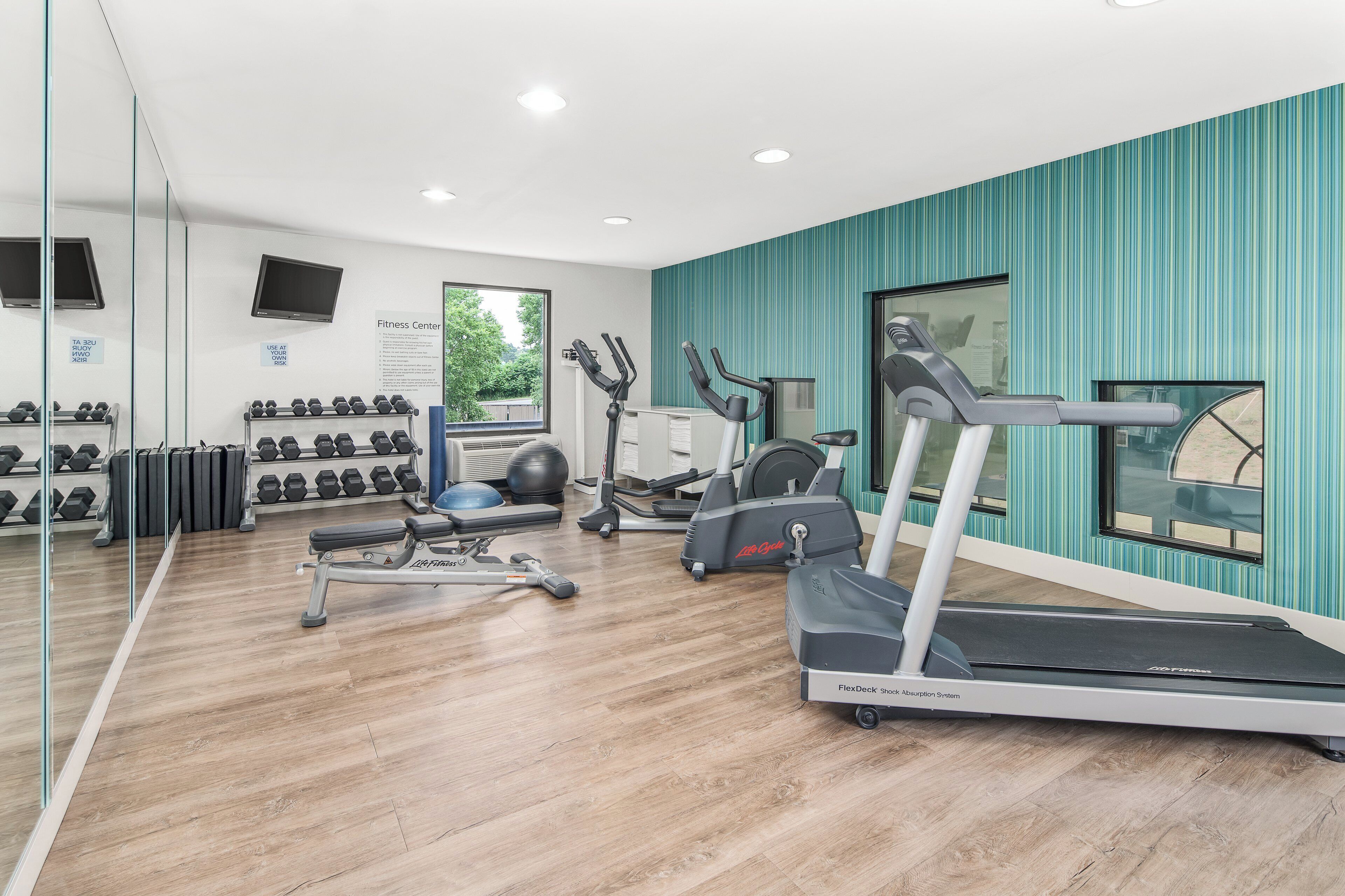 Una palestra con tapis roulant, ellittiche e pesi liberi.