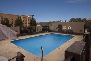 Una piscina al aire libre, sillones reclinables de piscina